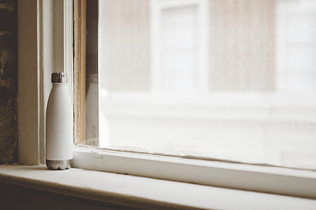 white insulated bottle beside closed glass window thumbnail