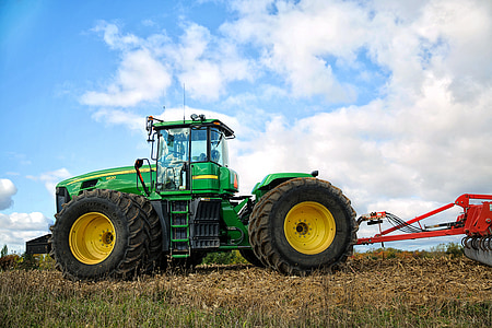 green and yellow tractor with cultivator at daytime thumbnail