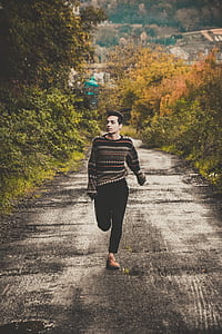 man walking between green plants thumbnail