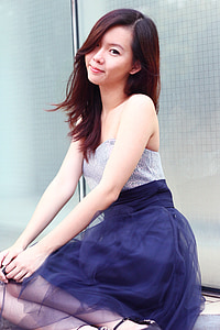 woman wearing gray and blue strapless dress while sitting on ground thumbnail