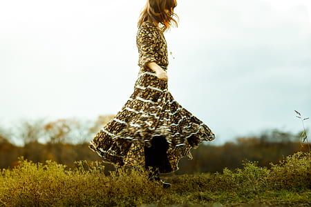 woman in brown and black dress on green grass field thumbnail