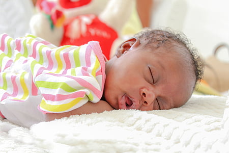 sleeping baby lying on white bed comforter thumbnail