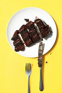 four slice chocolate cakes on plate beside fork and knife thumbnail