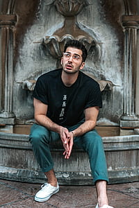 man sitting on gray concrete fountain thumbnail
