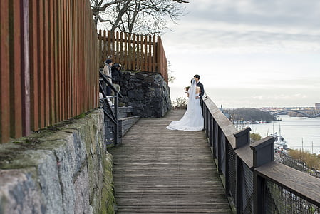 married couple beside gray wall during daytime thumbnail
