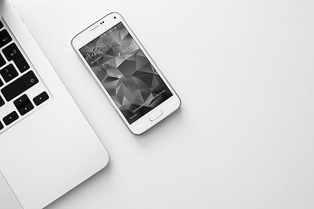 shimmery white Samsung Galaxy S5 mini beside MacBook thumbnail