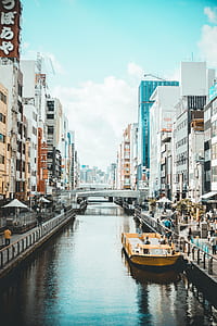 brown boat beside buildings thumbnail