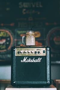 clear glass mason jar with coffee on black Marshall guitar amplifier thumbnail
