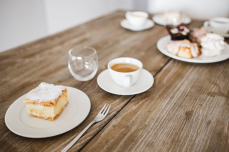 Sweet dessert with cream and a cup of coffee on a table thumbnail