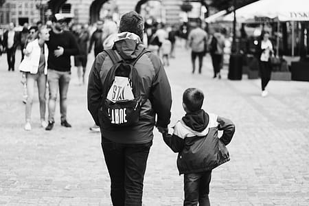 Grayscale Photography of Boy Holding Hand of Man thumbnail