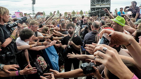 Man in Black Crew Neck T Shirt and Pants Playing Guitar Surrounded by Crowd thumbnail