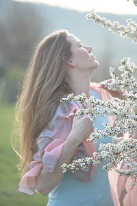 woman holding her scarf while standing near tree thumbnail
