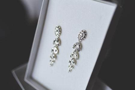 closeup photo of silver-colored floral drop earrings with box thumbnail