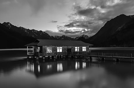 grayscale photo of house near body of water thumbnail