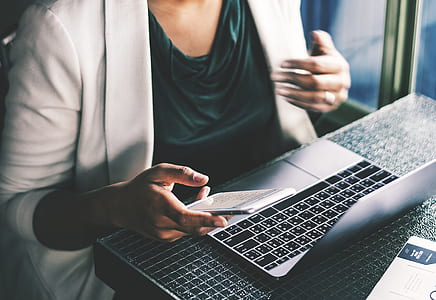 person holding phone in front of laptop thumbnail