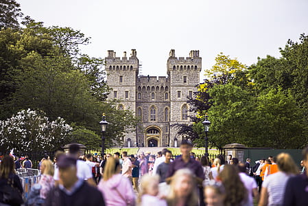 group of people walking in front of castle during daytime thumbnail