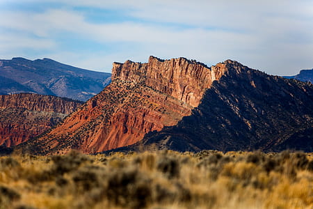 brown mountain under cloudy sky during daytime thumbnail