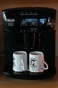 black Delonghi coffeemaker and two white ceramic mugs thumbnail