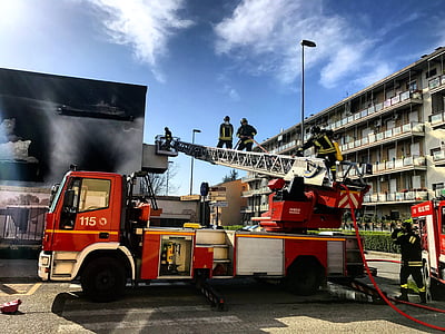 firetruck near billboard and building at daytime thumbnail