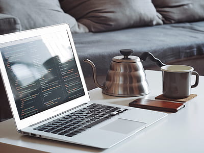 laptop, mug, phone, and teapot on table thumbnail