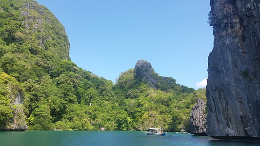 gray boat on body of water near mountains thumbnail