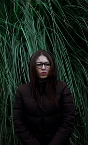 woman in brown jacket standing grasses thumbnail