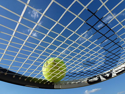 Wilson tennis ball on black and white Head tennis racket thumbnail