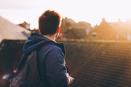 man carrying backpack looking at roof thumbnail