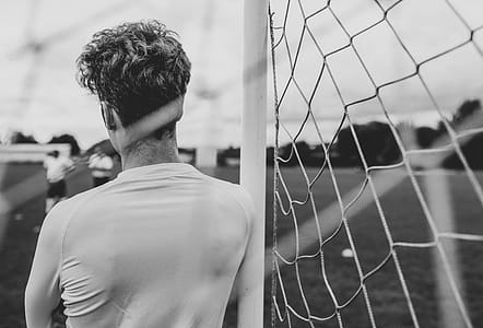 Grayscale Photography of Person Leaning on Goal thumbnail