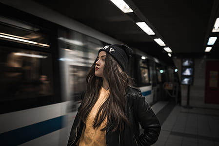 time-laps photography of woman standing beside train thumbnail