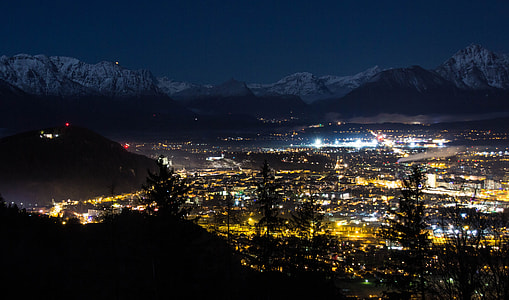 lighted cityscape near mountain at nighttime thumbnail