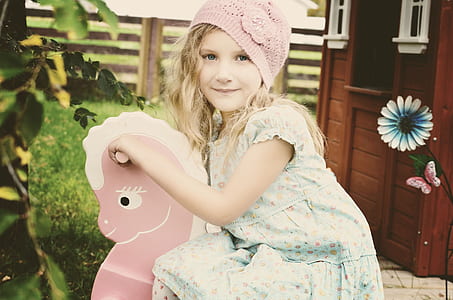 girl wearing floral dress sit on rocking horse thumbnail