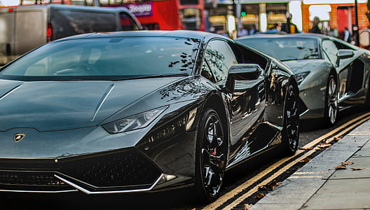 two black sports cars on parked on street thumbnail