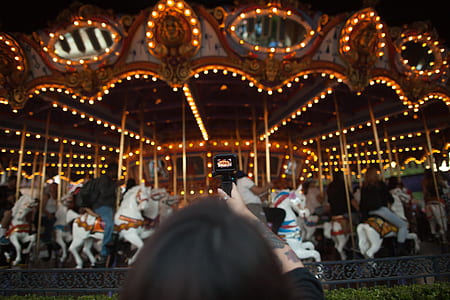 woman taking photo of carousel horse thumbnail