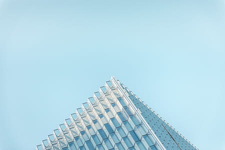 glass window skyscraper building under clear blue sky during daytime thumbnail