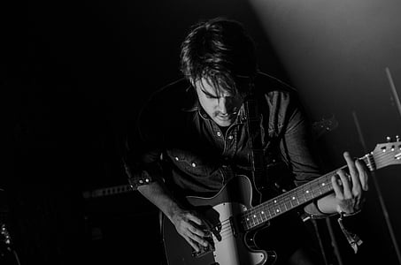 grayscale photo of man holding guitar thumbnail