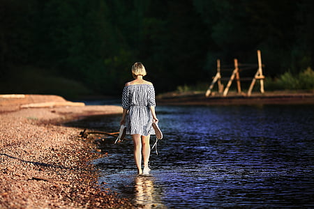 woman walking on body of water at daytime thumbnail