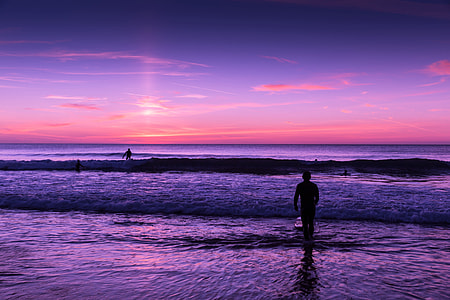 People in the ocean at sunset thumbnail