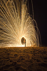 person holding fireworks on beach during nighttime thumbnail