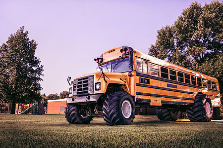 yellow school bus on grass field at daytime thumbnail