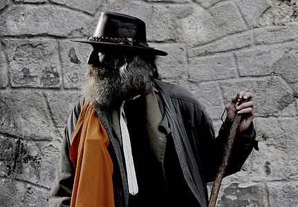 man wearing black coat and hat holding a staff thumbnail