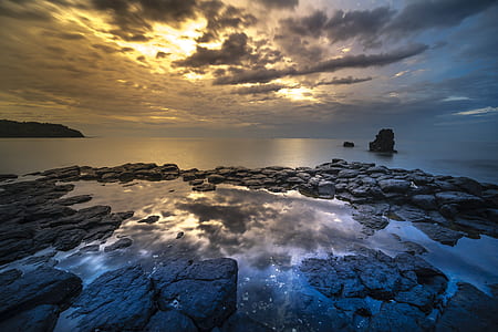 rocks near body of water during golden hour thumbnail