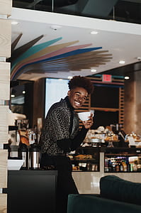 man smiling while holding a white teacup thumbnail