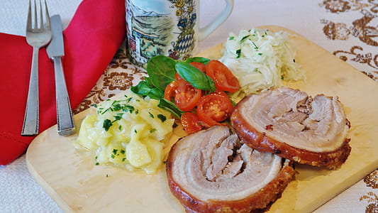 cooked meat and sliced vegetables on chopping board beside mug and fork thumbnail