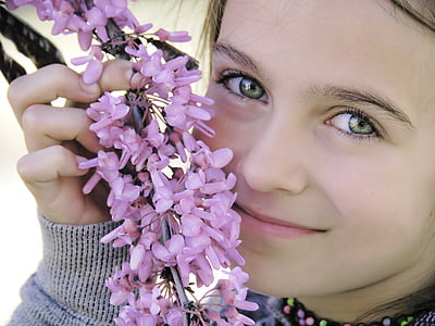 close-up photography of girl holding pink flowers thumbnail