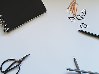 notebook and scissors on the table thumbnail