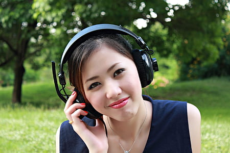 woman in blue sleeveless top and black headphones thumbnail