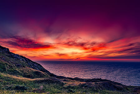 landscape photo of hill, sunset, and ocean thumbnail