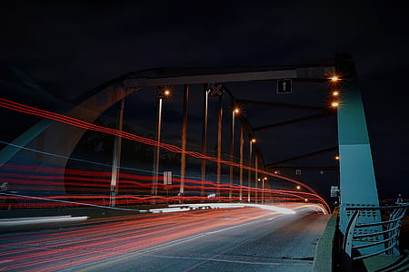 time lapse photo of gray bridge under dark sky thumbnail