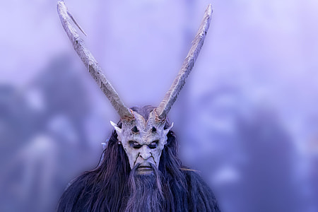 selective focus photo of person wears gray animal mask and horn thumbnail
